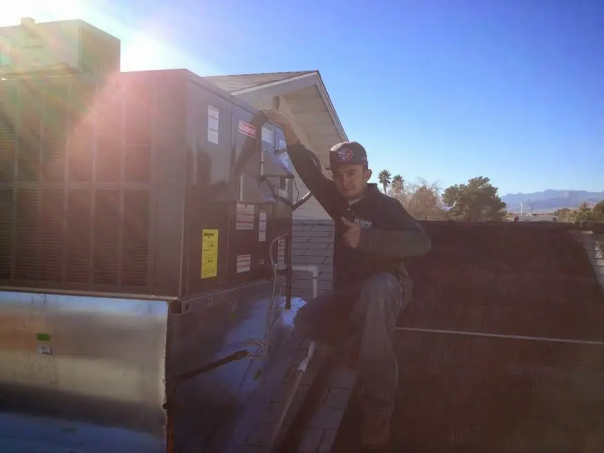 HVAC technician performing HVAC Inspection on a rooftop unit in Independence